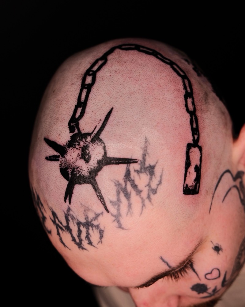 Completed tattoo on the head: a spiked ball on a chain, in black and dotwork